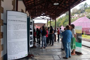 Participantes da abertura da Exposição Fotográfica da 7ª Oficina de Fotografia Digital visualizam fotografias, na plataforma da Estação Ferroviária de Ouro Preto. Foto: Wesley Maurício