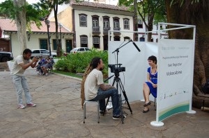 Marcello Nicolato, do Núcleo de Audiovisual do Vale Registrar, grava o depoimento de Margarete de Castro Amaral, fotografado por Wesley Maurício do Núcleo Audiovisual, na Praça Gomes Freire, em Mariana. Foto: Marianne Fonseca 
