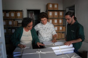 Em Itaúna, Minas Gerais, os pesquisadores Josanne Simões e Eder Melo, do Núcleo de História Oral do Vale Registrar, fazem a devolução dos documentos pesquisados da Companhia Industrial Ouropretana a Patrícia Gonçalves Nogueira, gerente administrativa da Massa Falida da Companhia Industrial Itaunense. Foto: Wesley Maurício