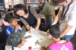 Cristiane Zago, e seu assistente José Célio Martins, da PICTOZ, auxiliam os alunos na montagem da animação com a técnica dos recortes de papel.